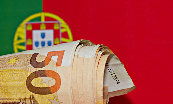 Casal em Lisboa a ler um contrato de empréstimo numa mesa de cozinha
